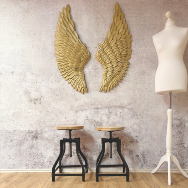 Selfie-Studio Setting mit Betonwand und goldenen Flügeln und Holzhockern